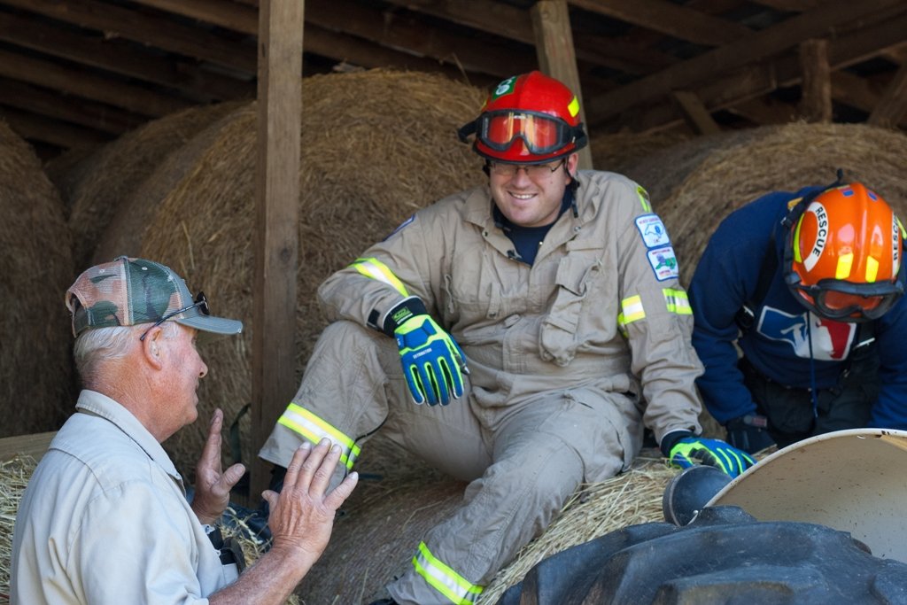 Fire fighter in protective gear sitting on hay bale