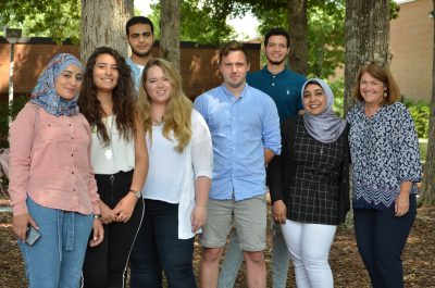 Group of seven international students pose with Director of International Education Suzanne LaVenture.