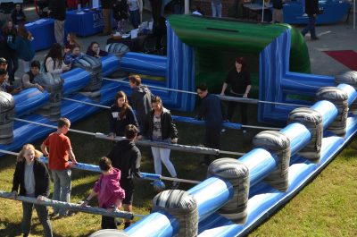 Students playing Human-sized inflatable foosball.
