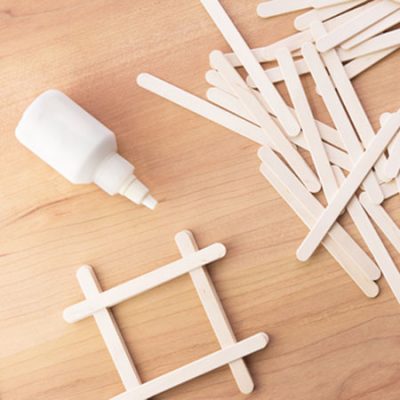 Wood sticks and glue crafting supplies on tabletop