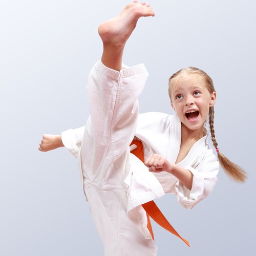 Young child in white karate suit and orange belt