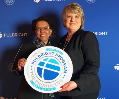 Dr. Rhonda Coats and Dr. Margaret Annunziata stand with "Fulbright Program Top Producing Institution 2019-2020" sign.