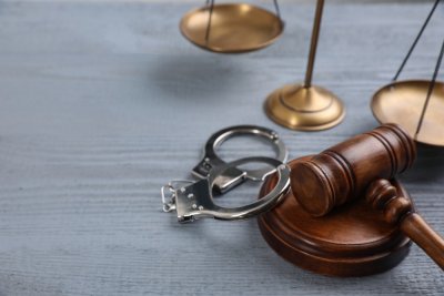 Gavel and Handcuffs on gray table