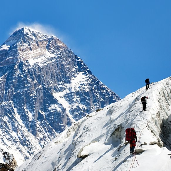 Three hikers climb snow covered Mount Everest