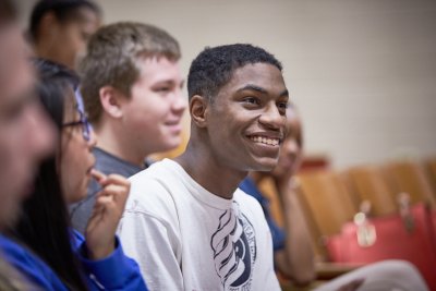 Smiling Student in white T-shirt in classroom