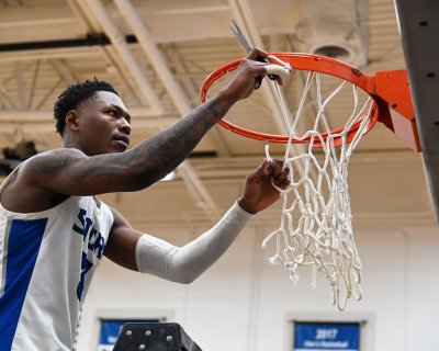 Forward Tim Boulware helps cut down the net after Saturday’s Region 10 championship win.
