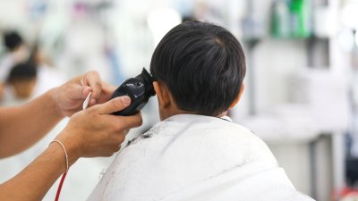 young child gets haircut with clippers