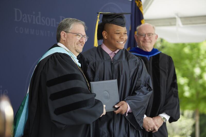 Graduate receives diploma from college president