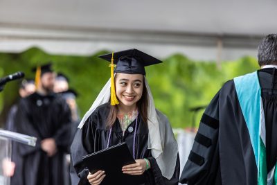 Graduate smiles as she receives diploma on staage