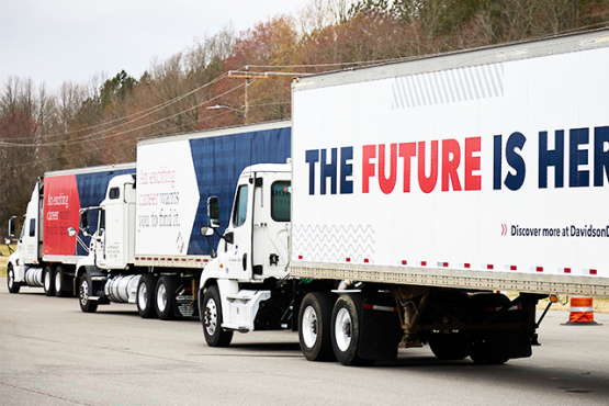 Three Davidson-Davie Community College branded tractor trailers arranged in a staggered line