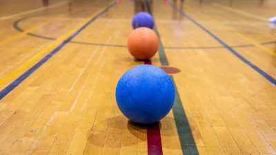Dodgeballs lined up on gym floor