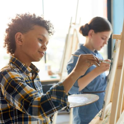 Young artist painting on canvas