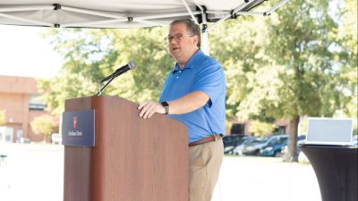 Darrin Hartness speaks from podium at outdoors event