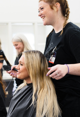 Two cosmetology students practice their craft