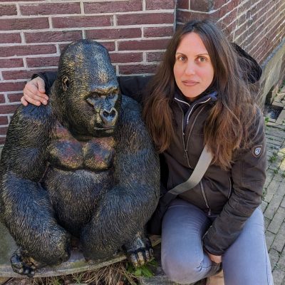 Amy Holmes poses with statue of gorilla.