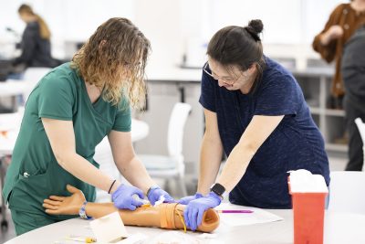 Two Medical Laboratory Technology Students Work with prosthetic arm