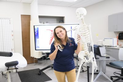 Massage instructor with classroom skeleton