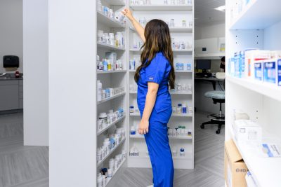 pharmacy student looks at pill bottles on shelf
