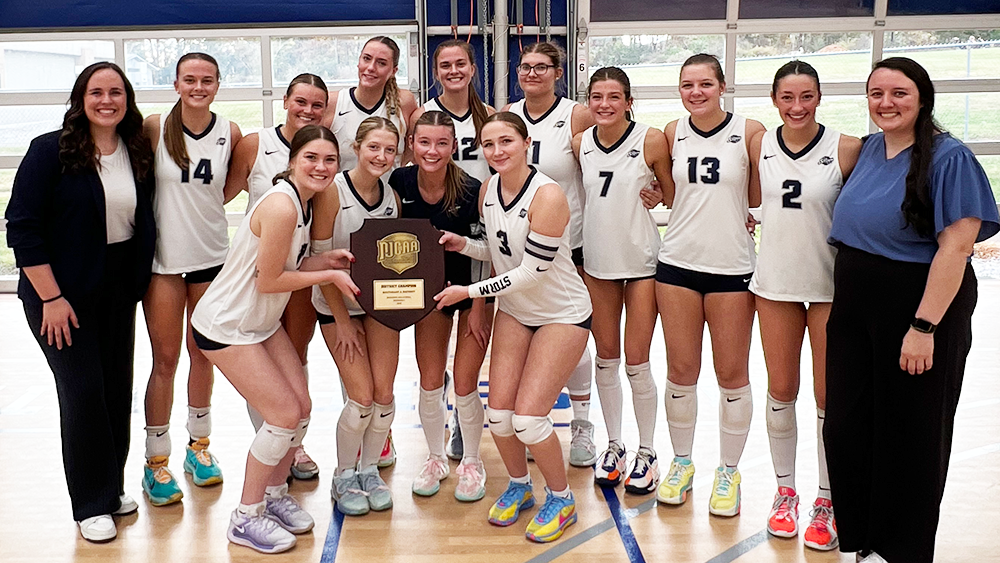 Davidson-Davie women's volleyball team posing after winning the D2 Southeast A District Championship.